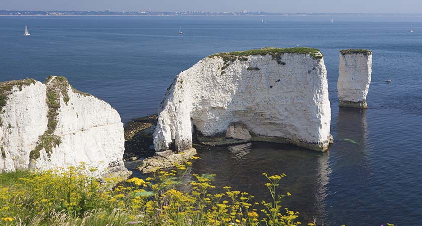 The Old Harry Rocks are chalk formations, located at Handfast Point, on the Isle of Purbeck in Dorset, southern England. (With Bournemouth in the background)