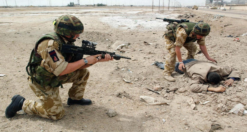 BASRA, IRAQ - APRIL 6: (U.S. AND CANADA SALES ONLY) Britain's 2 Company Irish Guards check a man dressed in civilian clothes April 6, 2003 in Basra, Iraq. British forces are pushing forward into Iraqi's second city, the majority of which is now under their control. (Getty) 