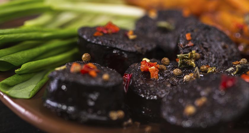 macro image of black pudding sausage with spices on a cutting board