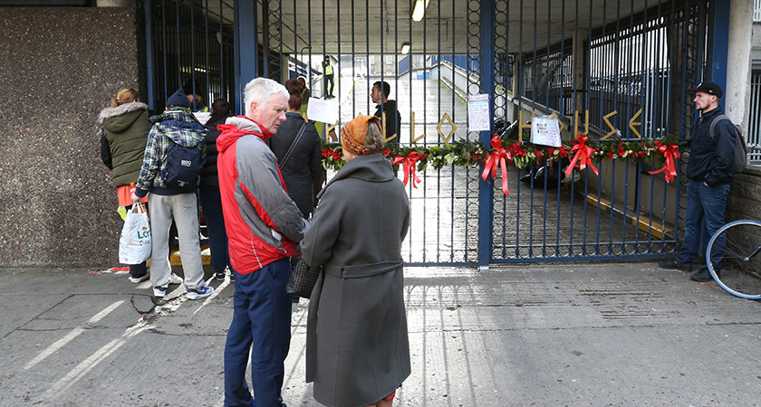 People stand guard in front of the Apollo House entrance. Photo (Rollingnews.ie)